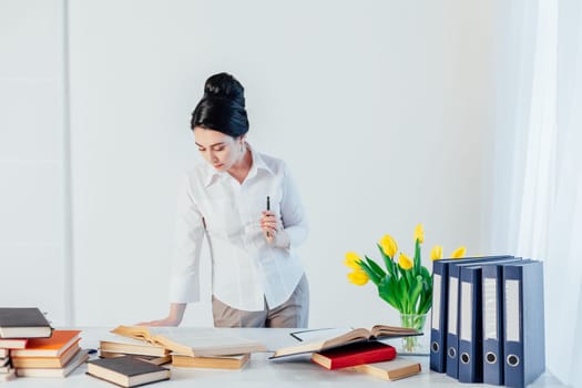 beautiful girl reads books at the table preparing for the exam 1