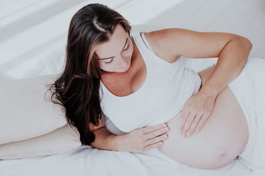 a pregnant woman is lying in bed waiting for the birth of a child 1