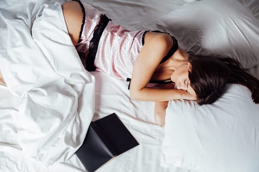 girl in pajamas lying on the bed with a book before bed 1
