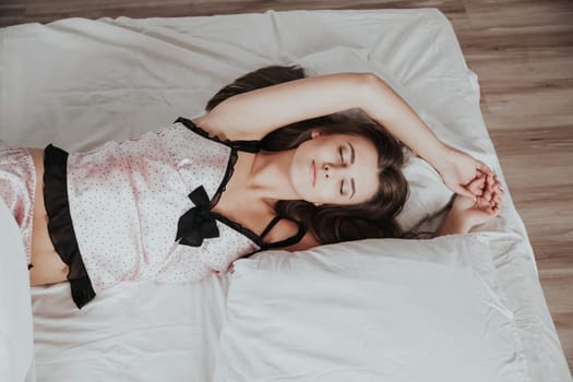 beautiful girl in pajamas asleep on a bed with white linen