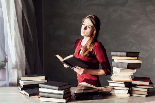 girl reads a lot of books at home at the table