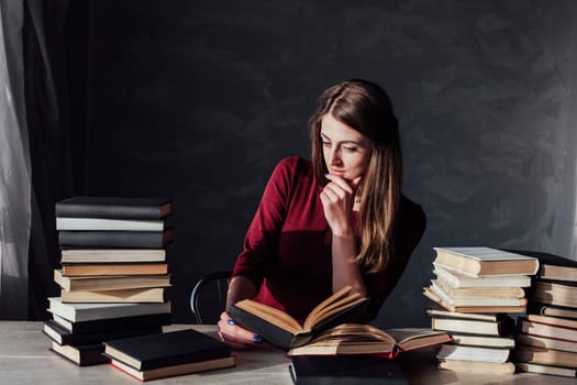 the girl sitting at the table reading a lot of books library