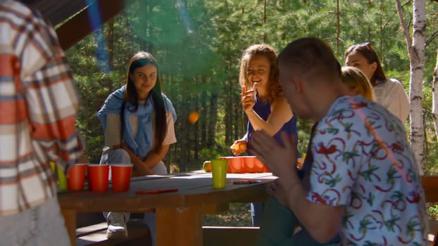 Woman plays beer pong. Stock footage. Beautiful young woman wins at beer pong. Friends rejoice at victory in beer pong in nature in summer.