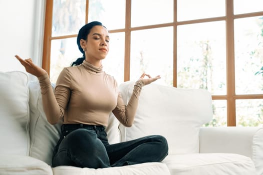 Young African American woman practice crucial mindful meditation at home living room for improving mental health strength and peaceful beautiful living