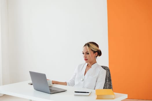 woman in office working on laptop online