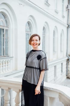 woman in black clothes posing near a white building