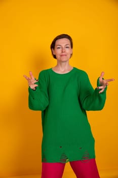 Beautiful woman in green sweater on yellow autumn background