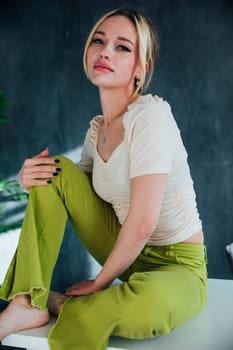 fashionable woman sitting on white table