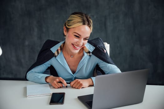 Business woman conducting financial negotiations online on phone and laptop