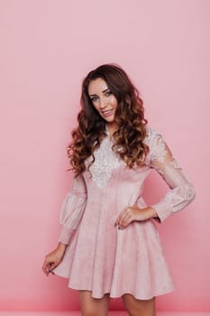 Portrait of a beautiful woman with hair curls in a pink dress