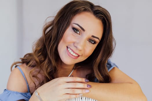 Portrait of a beautiful woman with hair curls in a blue dress