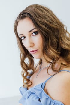 Portrait of a beautiful woman with hair curls in a blue dress