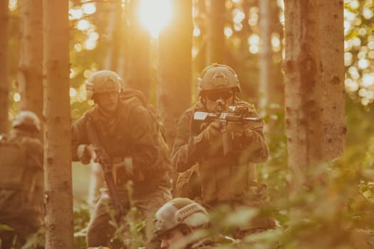 A group of modern warfare soldiers is fighting a war in dangerous remote forest areas. A group of soldiers is fighting on the enemy line with modern weapons. The concept of warfare and military conflicts.