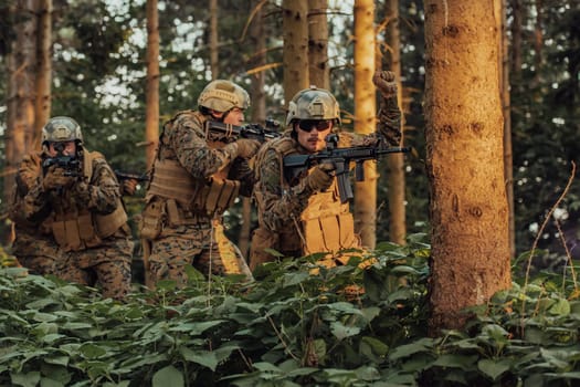 A group of modern warfare soldiers is fighting a war in dangerous remote forest areas. A group of soldiers is fighting on the enemy line with modern weapons. The concept of warfare and military conflicts.