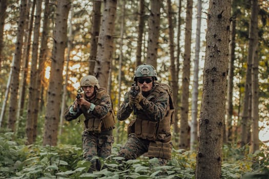 A group of modern warfare soldiers is fighting a war in dangerous remote forest areas. A group of soldiers is fighting on the enemy line with modern weapons. The concept of warfare and military conflicts.