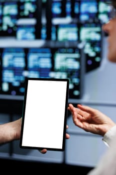 Close up of mock up tablet used by supervisor and assistant in cloud computing server facility delivering massive computational power, capable of processing and storing vast amounts of datasets