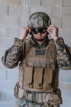 Soldier preparing tactical protective and communication gear for action battle.