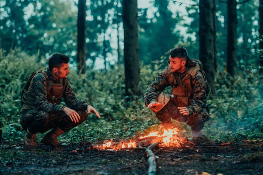 Two exhausted soldiers sitting by the fire after a weary and heavy war battle.