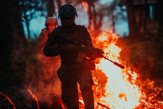 Soldier in Action at Night in the Forest Area. Night Time Military Mission jumping over fire.