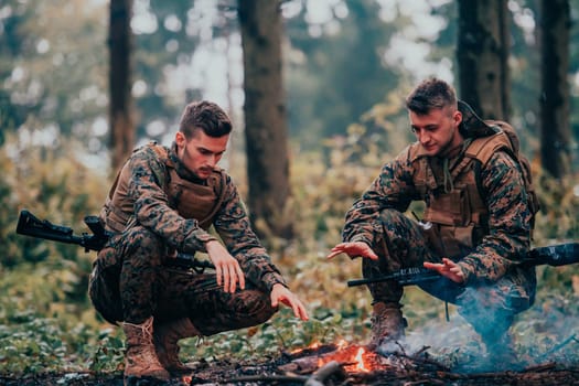 Two exhausted soldiers sitting by the fire after a weary and heavy war battle.