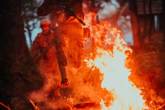 Soldier in Action at Night in the Forest Area. Night Time Military Mission jumping over fire.