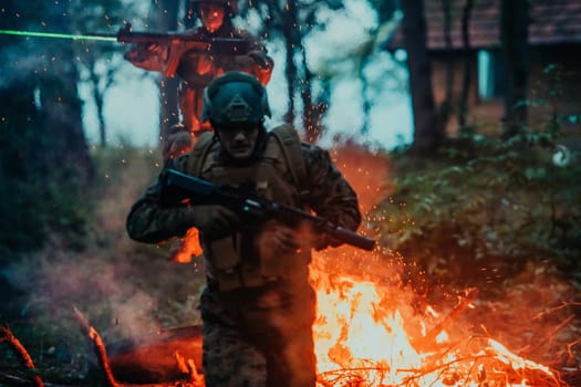 Soldier in Action at Night in the Forest Area. Night Time Military Mission jumping over fire.