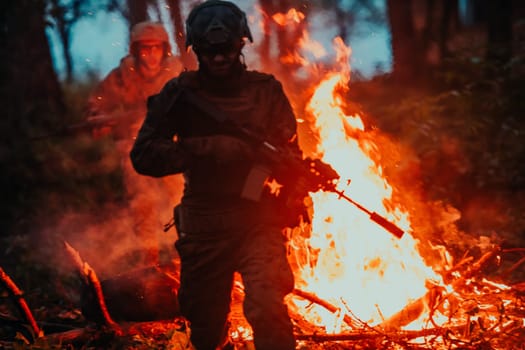 Soldier in Action at Night in the Forest Area. Night Time Military Mission jumping over fire.