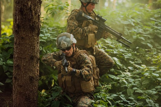 A group of modern warfare soldiers is fighting a war in dangerous remote forest areas. A group of soldiers is fighting on the enemy line with modern weapons. The concept of warfare and military conflicts.