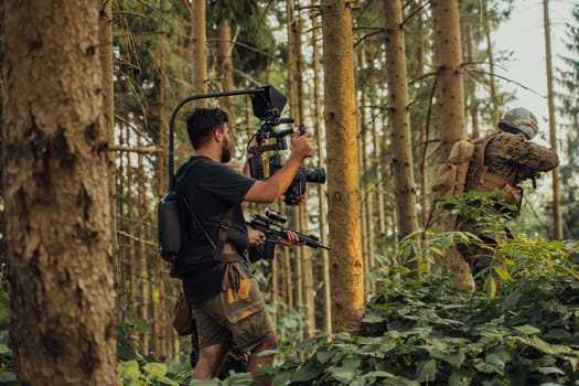 Videographer with Professional Movie Video Camera Gimbal Stabilizing Equipment Taking Action Shoot of Soldiers in Action in Forest.