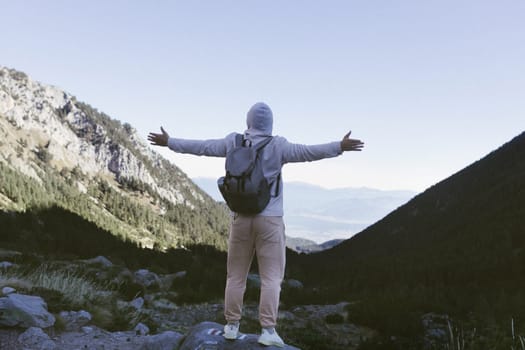 A tourist stands on the peak of a mountain