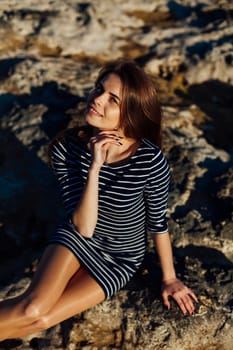 Portrait of a beautiful girl in a striped dress and long hair