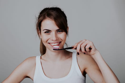 girl holding a toothbrush smiles 1 2