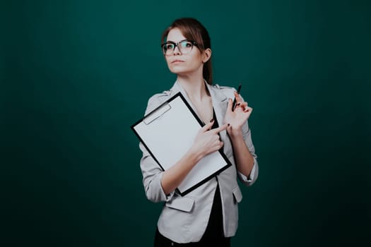 teacher with papers in green boards 1 2