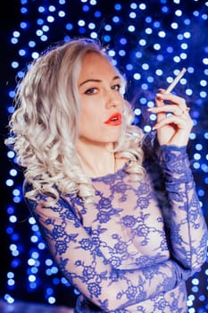 sexy blonde smokes a cigarette in blue lingerie red lips