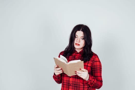 girl in a red shirt reads a book