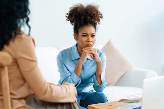 Sad PTSD woman patient in crucial therapy for mental health with psychologist, depression or grief after life failure. Frustrated trauma young woman talking to a psychologist about emotion in clinic