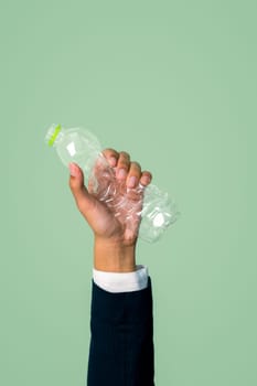 Businessman's hand holding plastic bottle on isolated background. Eco-business recycle waste policy in corporate responsibility. Reuse, reduce and recycle for sustainability environment. Quaint