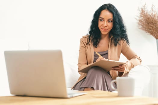 African-American woman using laptop computer for crucial work on internet. Secretary or online content writing working at home.