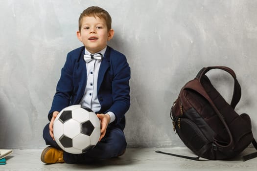 A little schoolboy, studying . A male child sitting on the floor