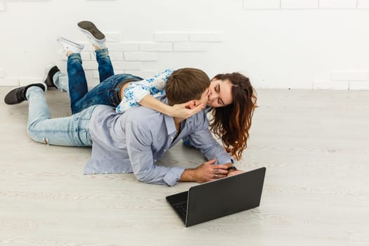 Portrait of happy young couple using laptop on gray background.
