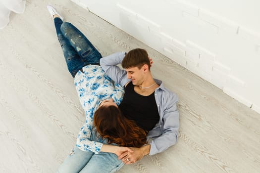 happy young couple have fun and relax in their new big bright home apartment