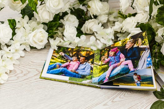 Family photos archive saved in brightly designed photo book; bright summer memories placed in the photobook