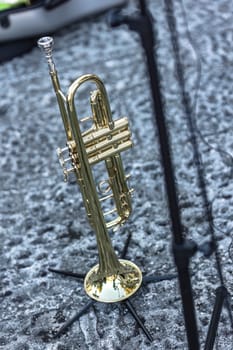A detailed view of a trumpet set up and waiting, poised for a live concert performance.