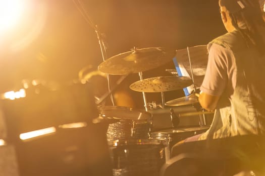 A dynamic shot of a drummer performing at a fog-filled night concert, creating an atmospheric scene.