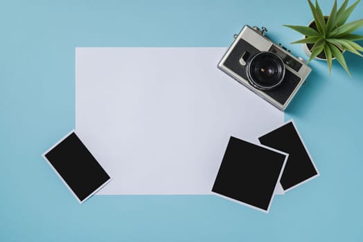 Vintage photo camera and empty photo frames on blue background. Travel moment concept