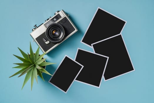 Vintage photo camera and empty photo frames on blue background. Travel moment concept