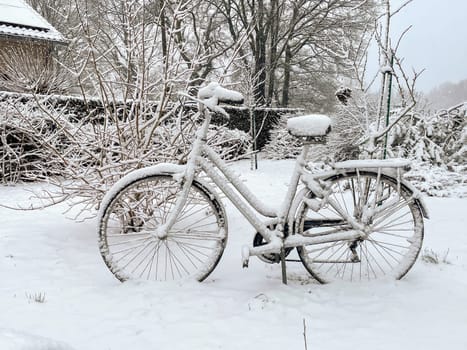 A bicycle under the snow is parked in a park full of fresh deep snow, Abandoned forgotten bicycle with snow cover in winter, covered with snow, broom Winter in the city, High quality photo
