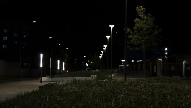 Lantern burning on a pole at night in the park. Stock footage. Glowing modern lantern in the Park at night.