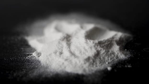 DRUGS: Man does a lines of heroin by plastic card - Close up. Plastic card and white powder. Lines and pile of cocaine on wooden table. Macro.
