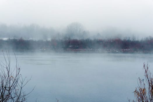 Body of water surrounded by trees and fog. Mysticism nature, tranquility